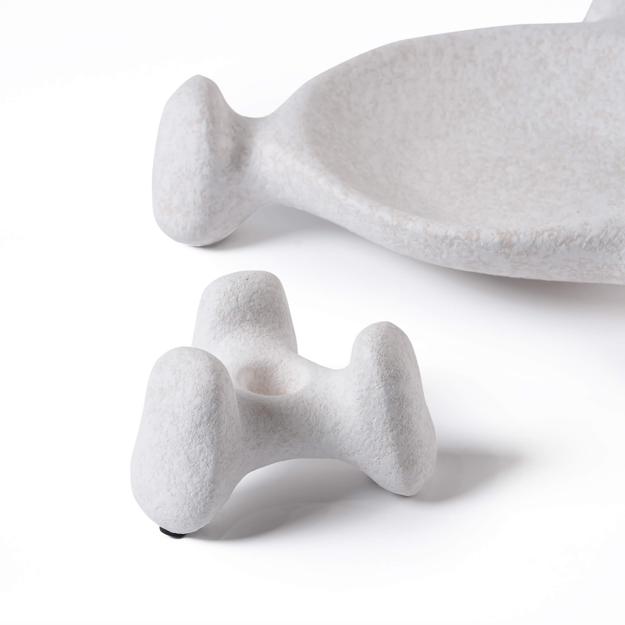 Close up of a quirky three-leg ceramic candle base showing the half-glaze matte finish