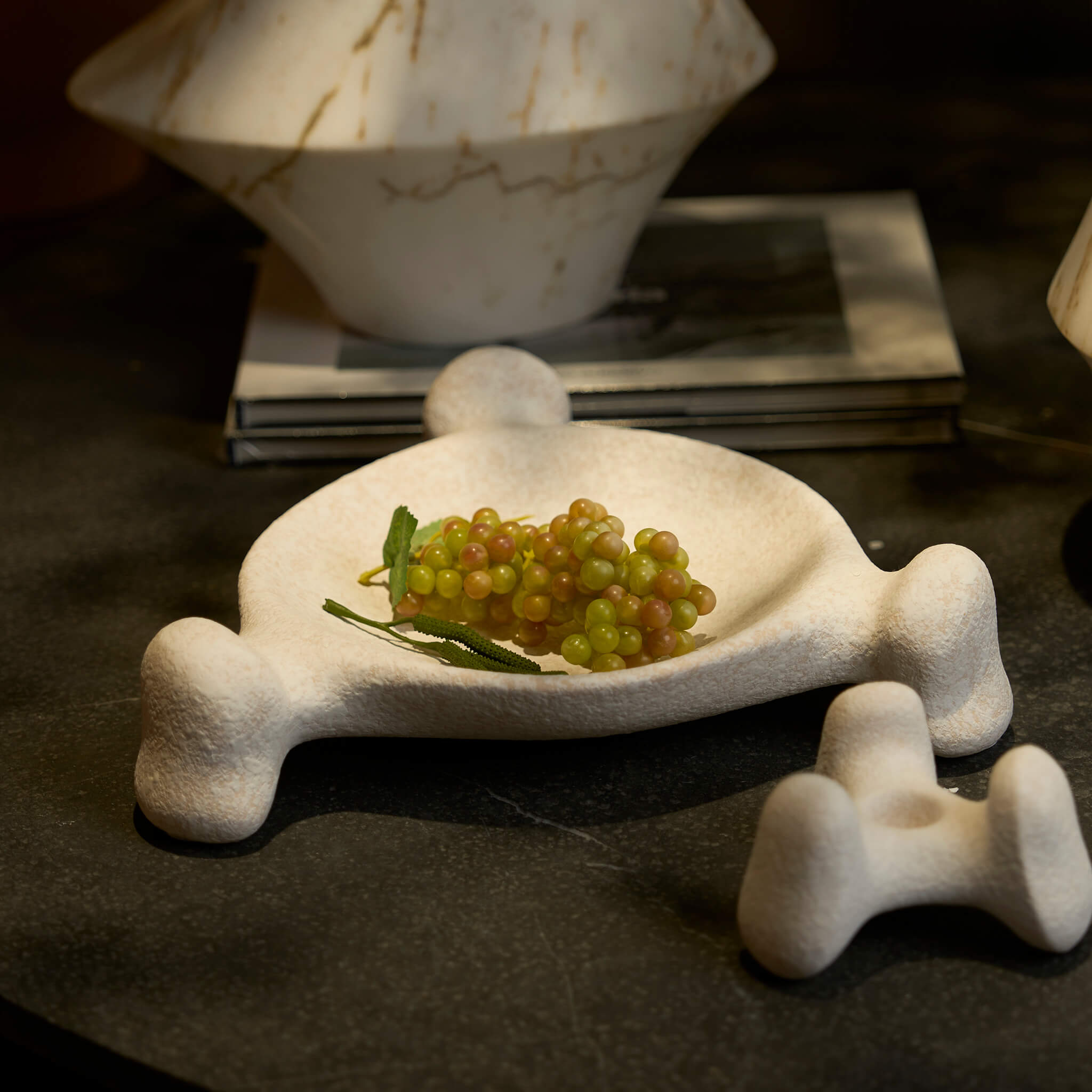 Sculptural ceramic candle holder and tray set decorating a modern minimalist living space