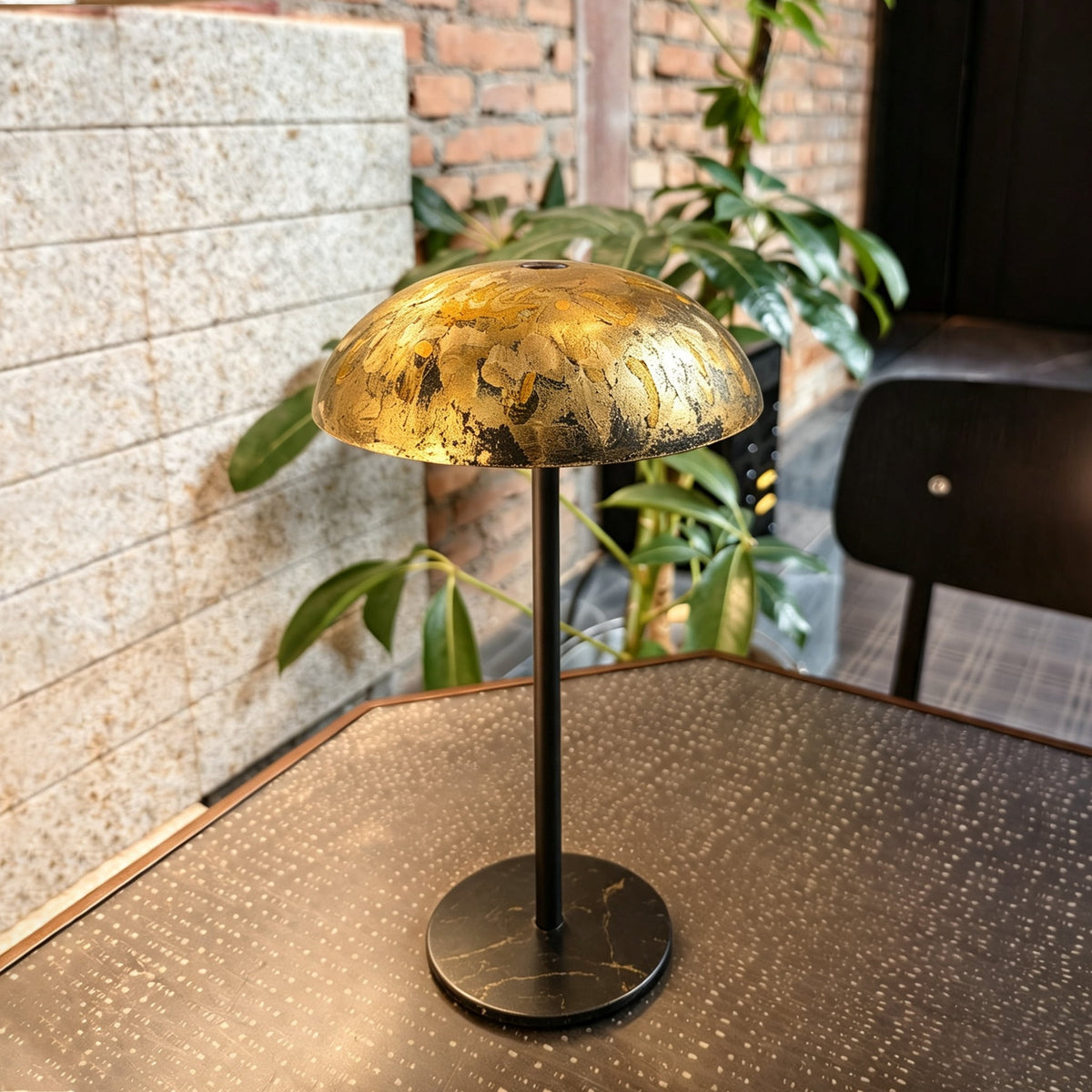 Gold hand-painted Relax-W DIY table lamp with a black base displayed on a patterned table in a warm contemporary interior.