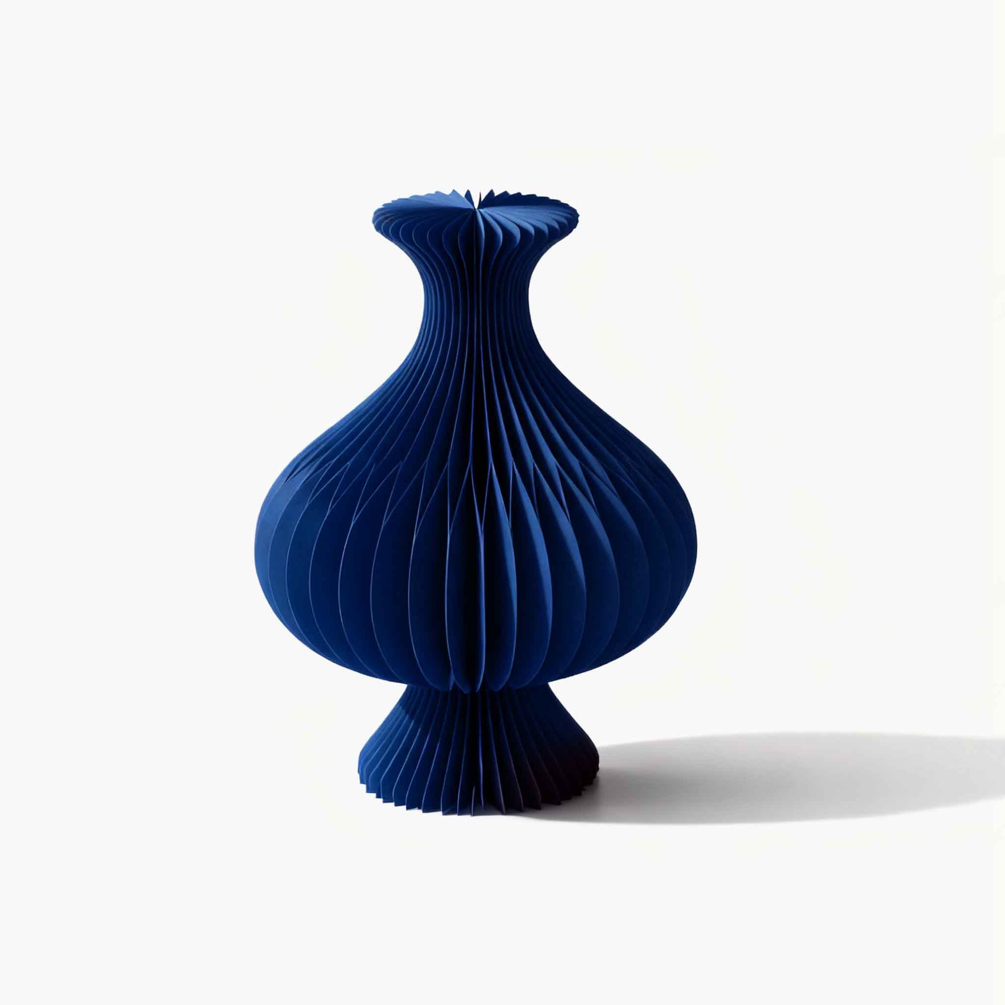 Minimalist blue foldable kraft paper floral centerpiece, perfect for curating fresh blooms on a quiet luxury desktop.
