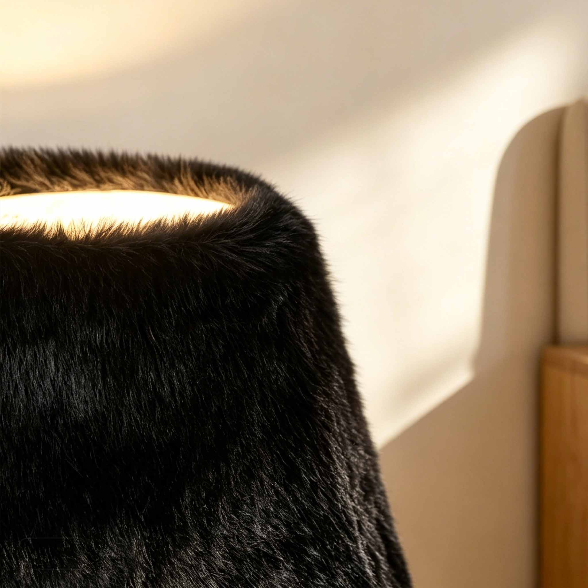 Tactile black faux fur material glowing under warm modern illumination