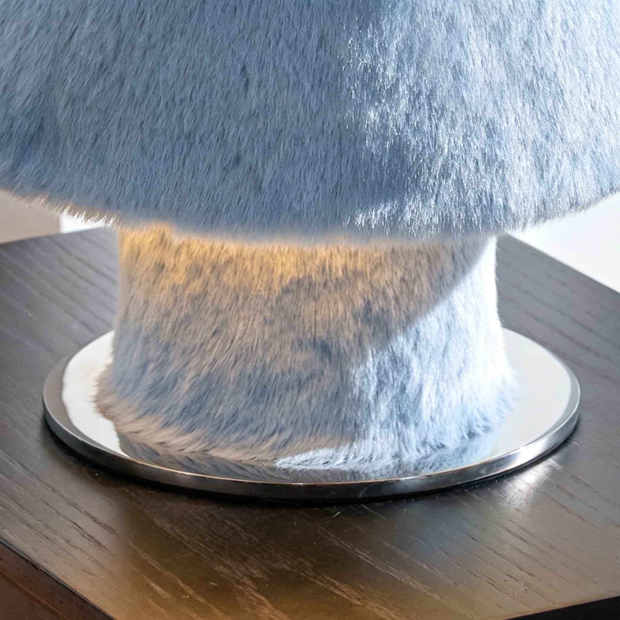 Detail of the plush blue base and soft light diffusing from the lamp