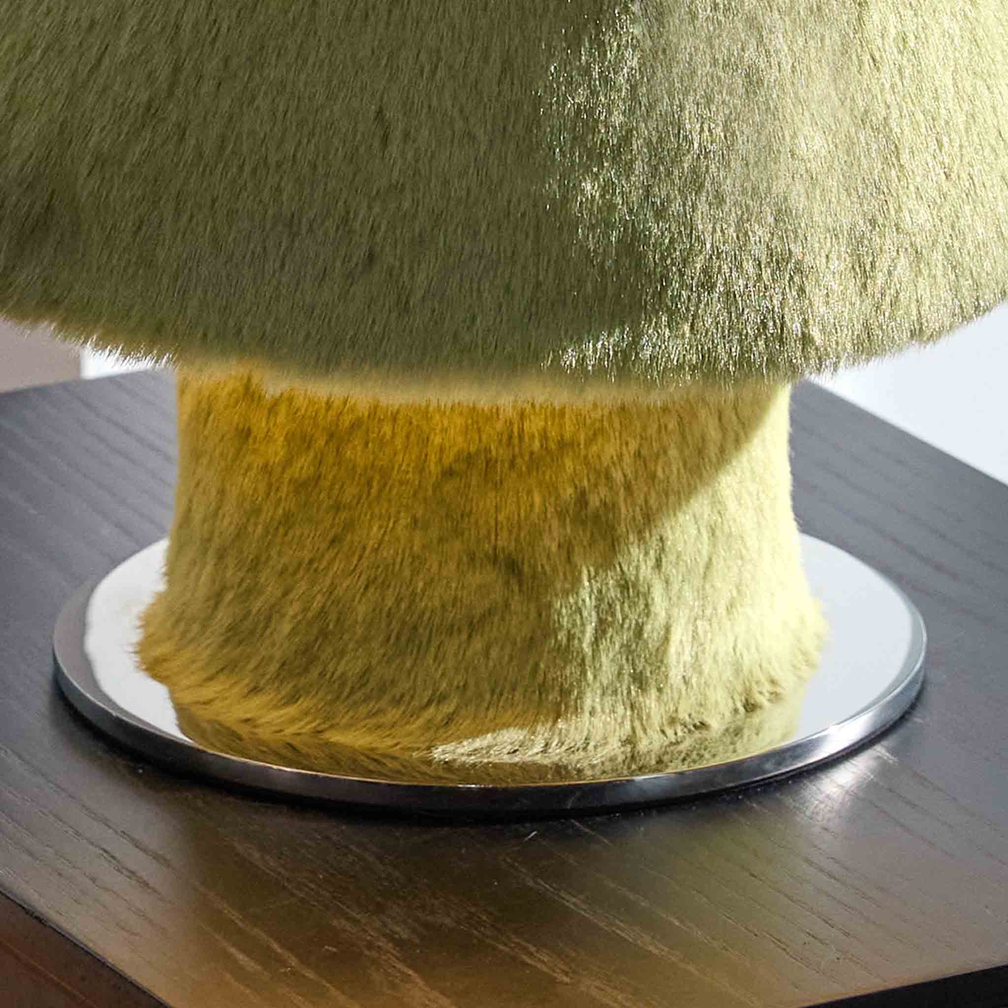Detail of the plush green base and soft light diffusing from the lamp
