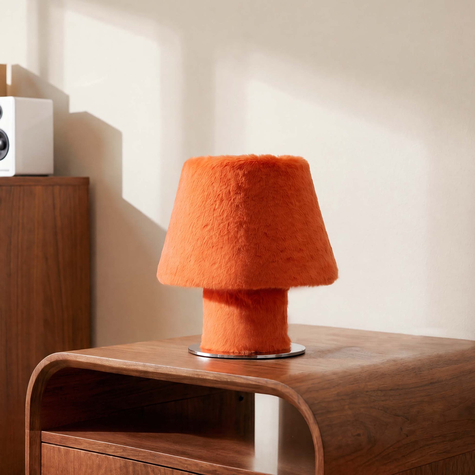 Orange luxury faux fur table lamp illuminating a modern wooden desk