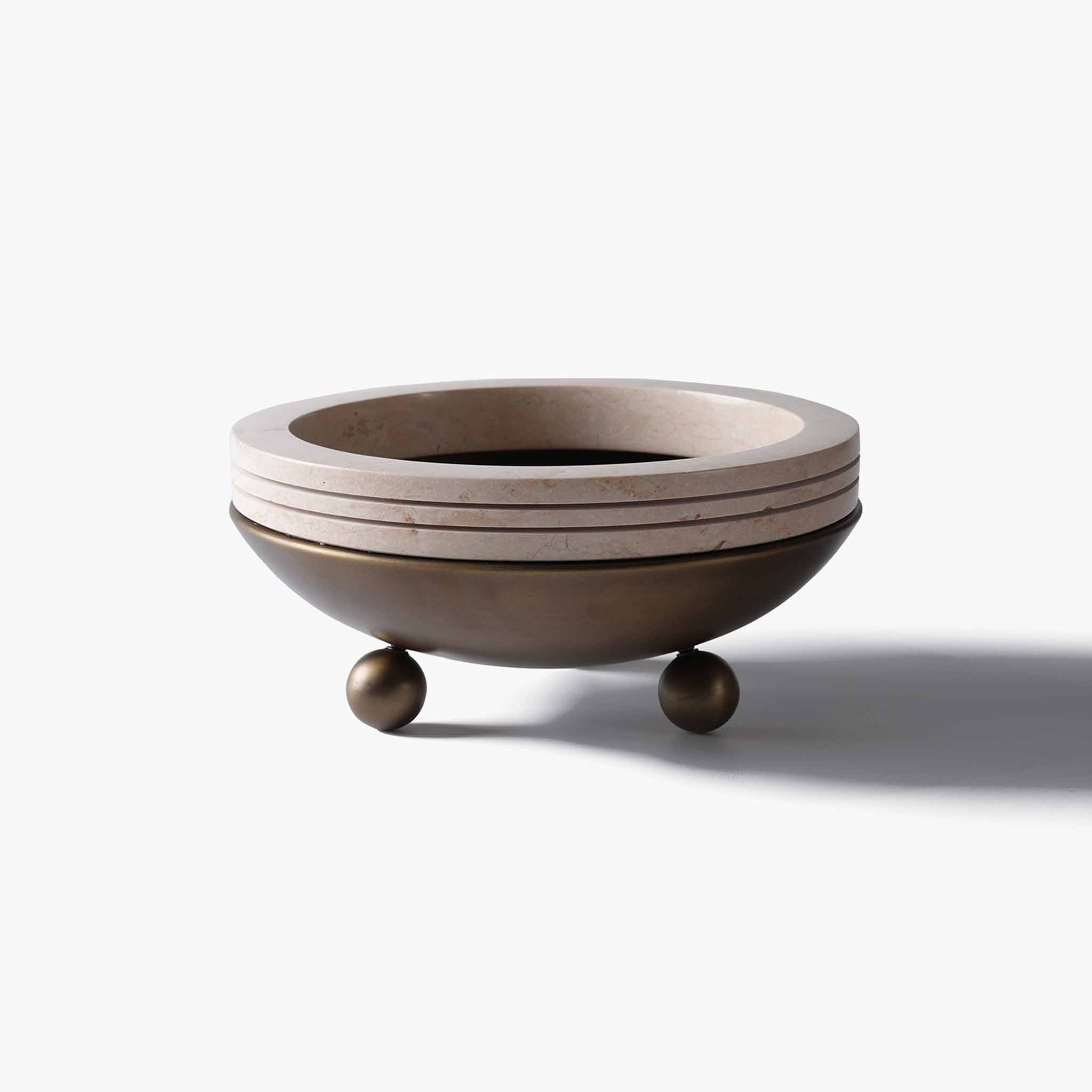 Front view of a low-profile decorative bowl featuring an antique bronze metal base and layered yellow travertine rim