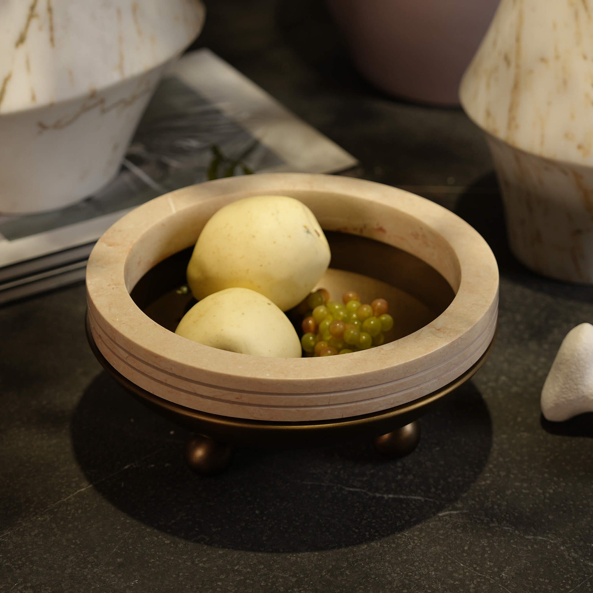 Close-up of the travertine centerpiece bowl holding fruit in a warm, elegantly lit modern living room setting