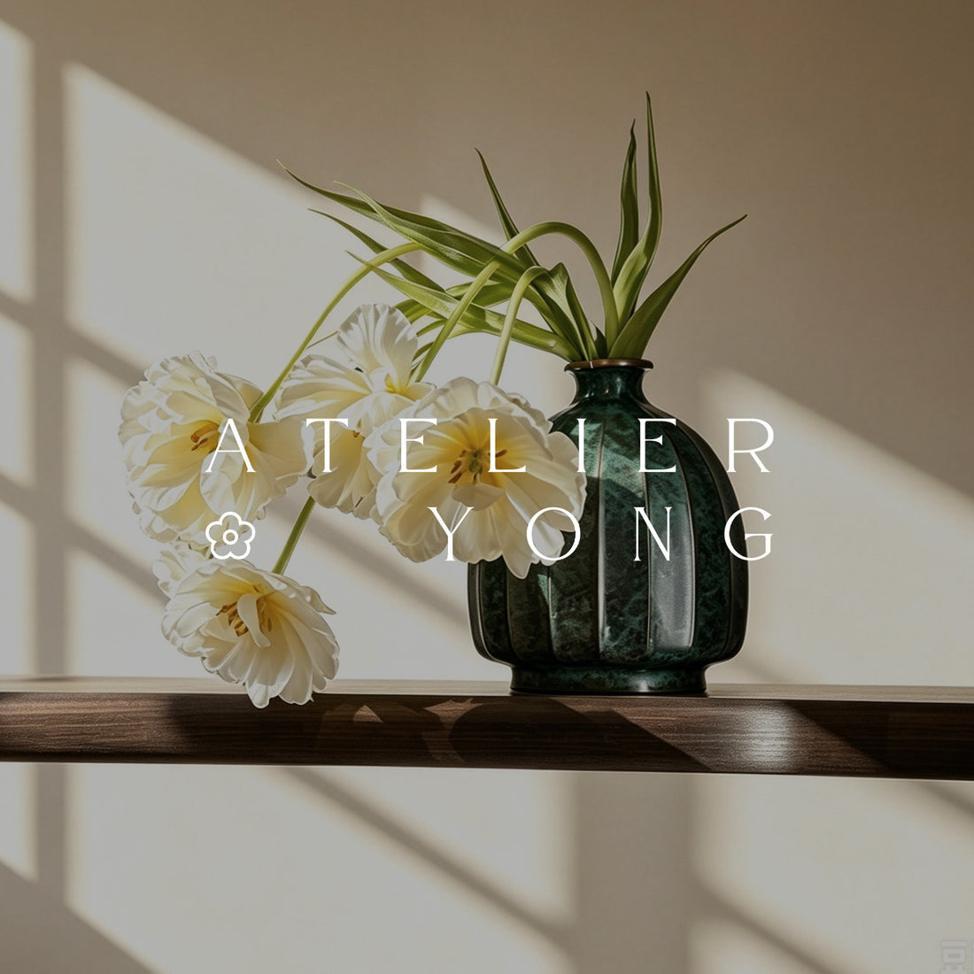 ATELIER YONG brand banner featuring a green ceramic vase with white flowers in warm natural sunlight.