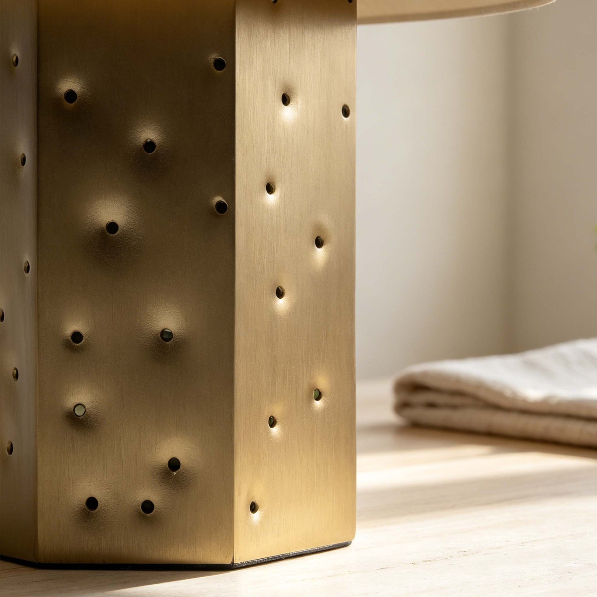 Close-up of the brushed metal night light body with starry perforated holes and soft warm light.