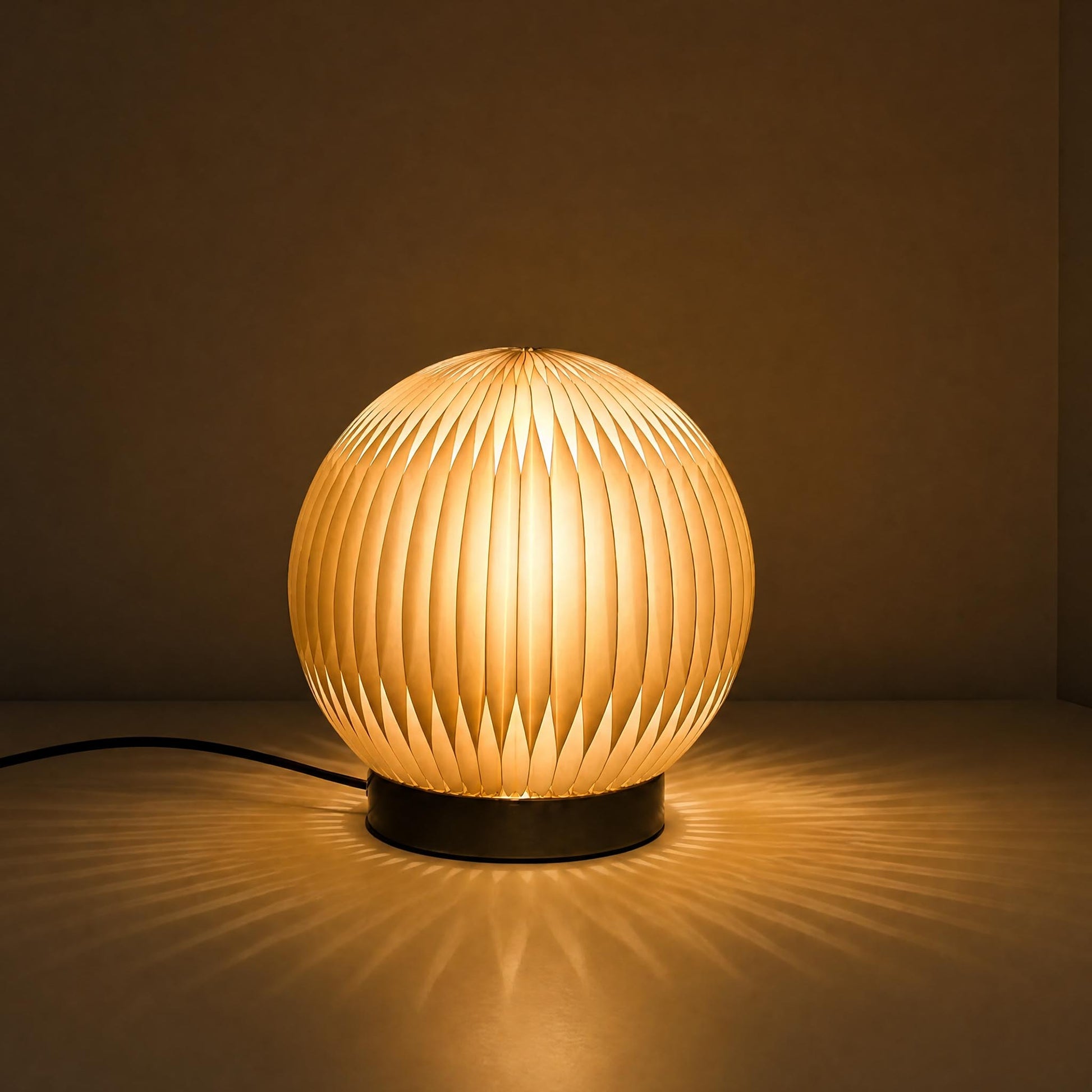 Crescent Moon accordion paper desk lamp with warm diffused light and a sculptural round shade.