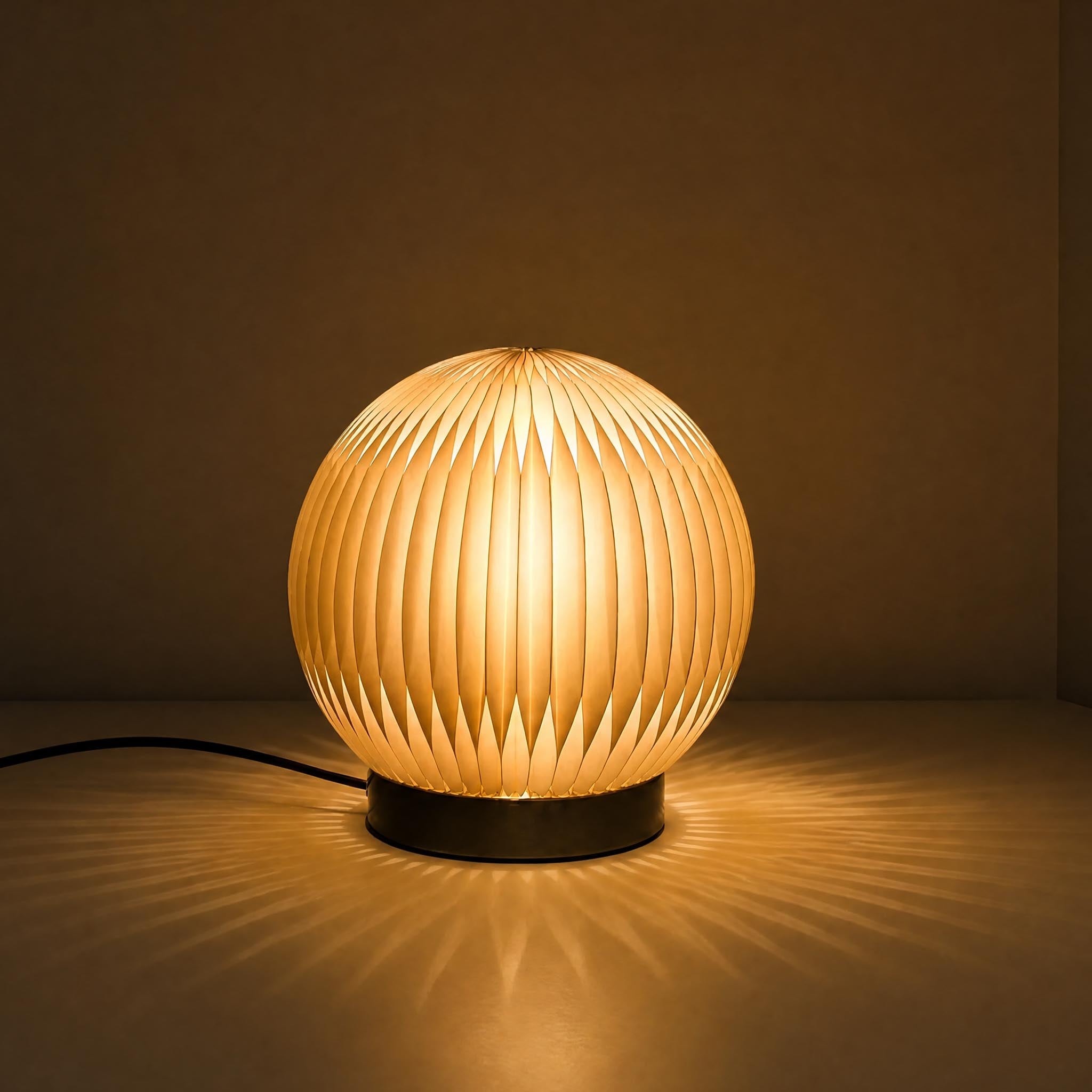 Crescent Moon accordion paper desk lamp with warm diffused light and a sculptural round shade.