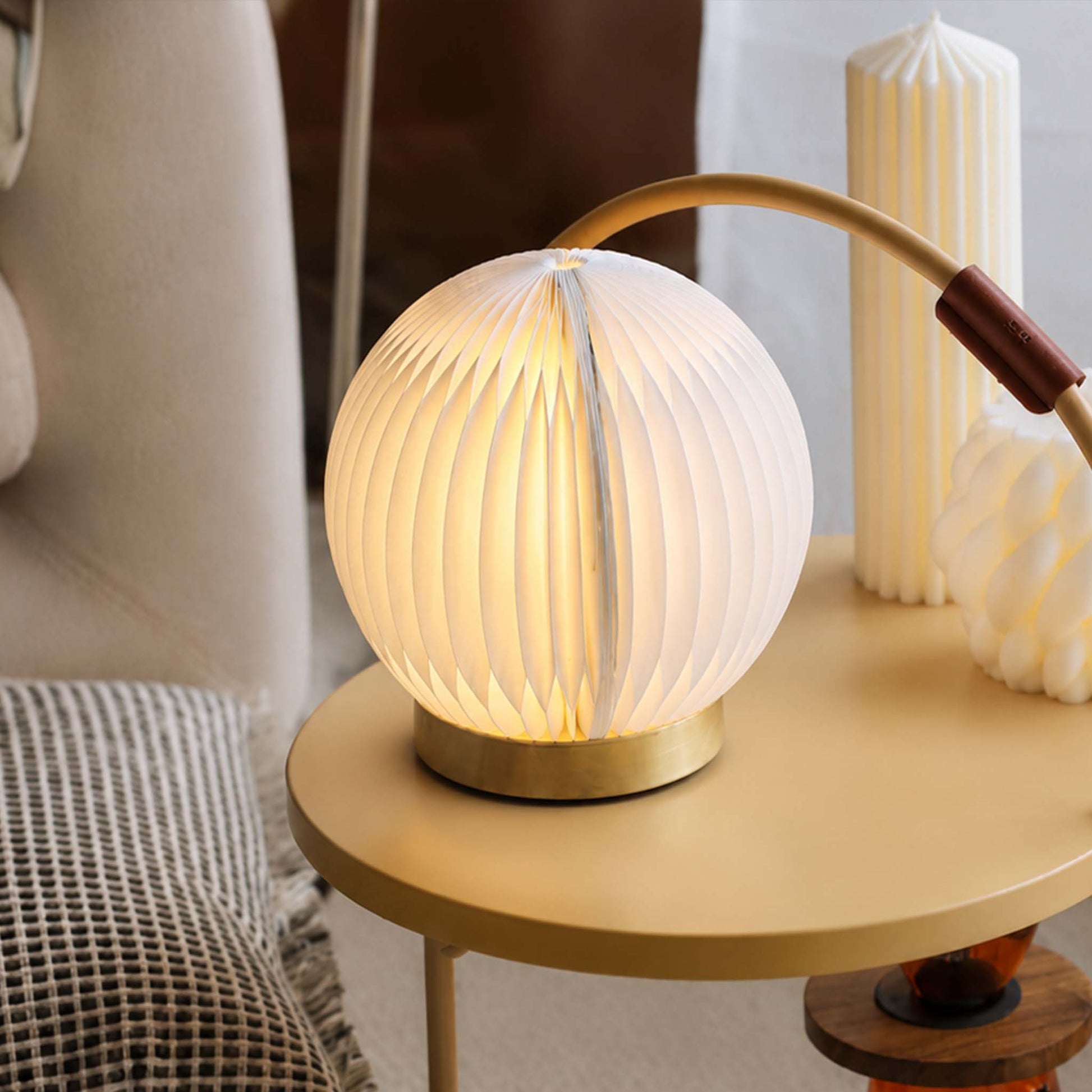 White Crescent Moon desk lamp with a folded paper shade on a modern side table with warm ambient light.