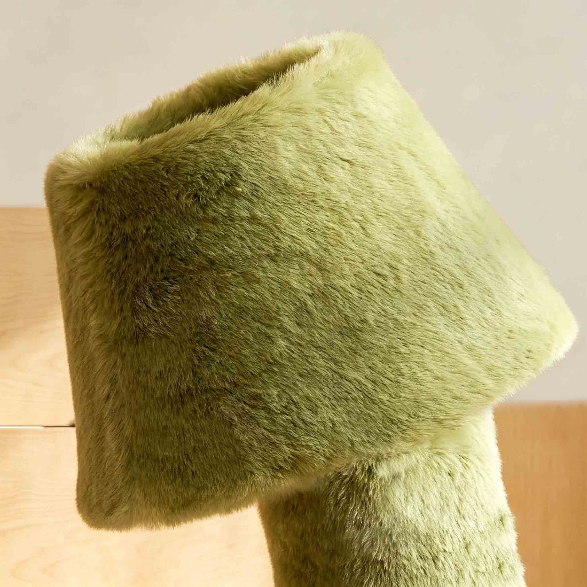 Close-up of the green faux fur lamp shade showing its soft plush texture and sculptural rounded form.