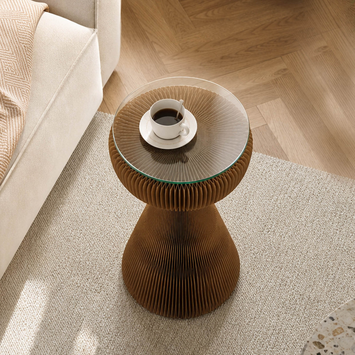 Top view of the brown Little Black Dress Side Table with round glass top and coffee cup in a neutral living room