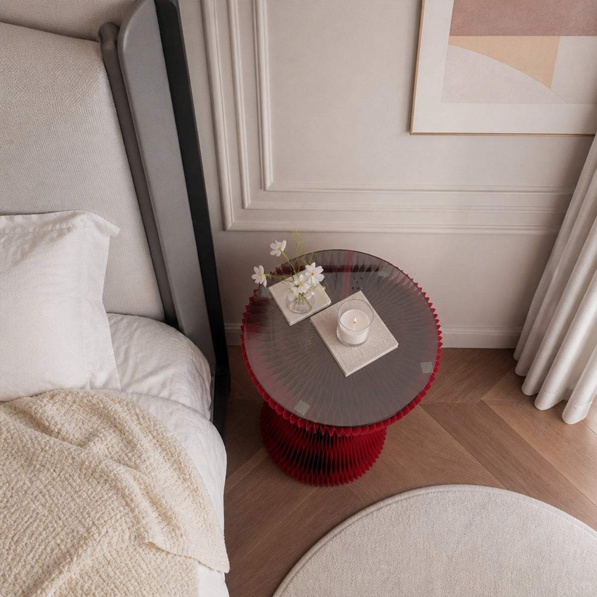 Top view of the red Little Black Dress Side Table with glass top, flowers and candle beside a bed