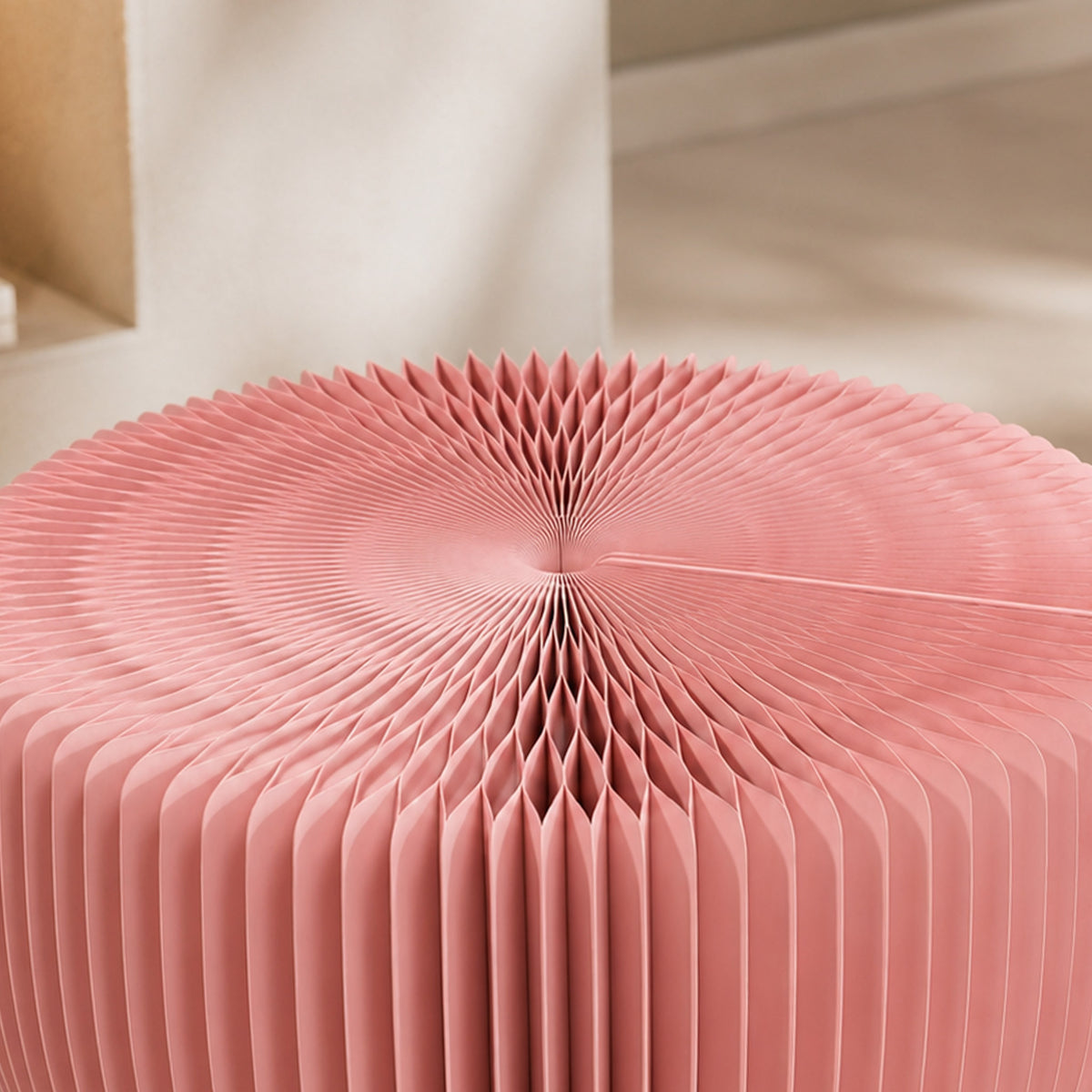 Close-up of the pink LOTUS Stool A showing the expandable honeycomb paper cells and foldable construction