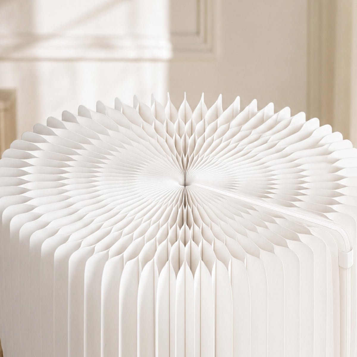 Close-up of the white LOTUS Stool A revealing the expandable honeycomb paper structure beneath the removable cushion