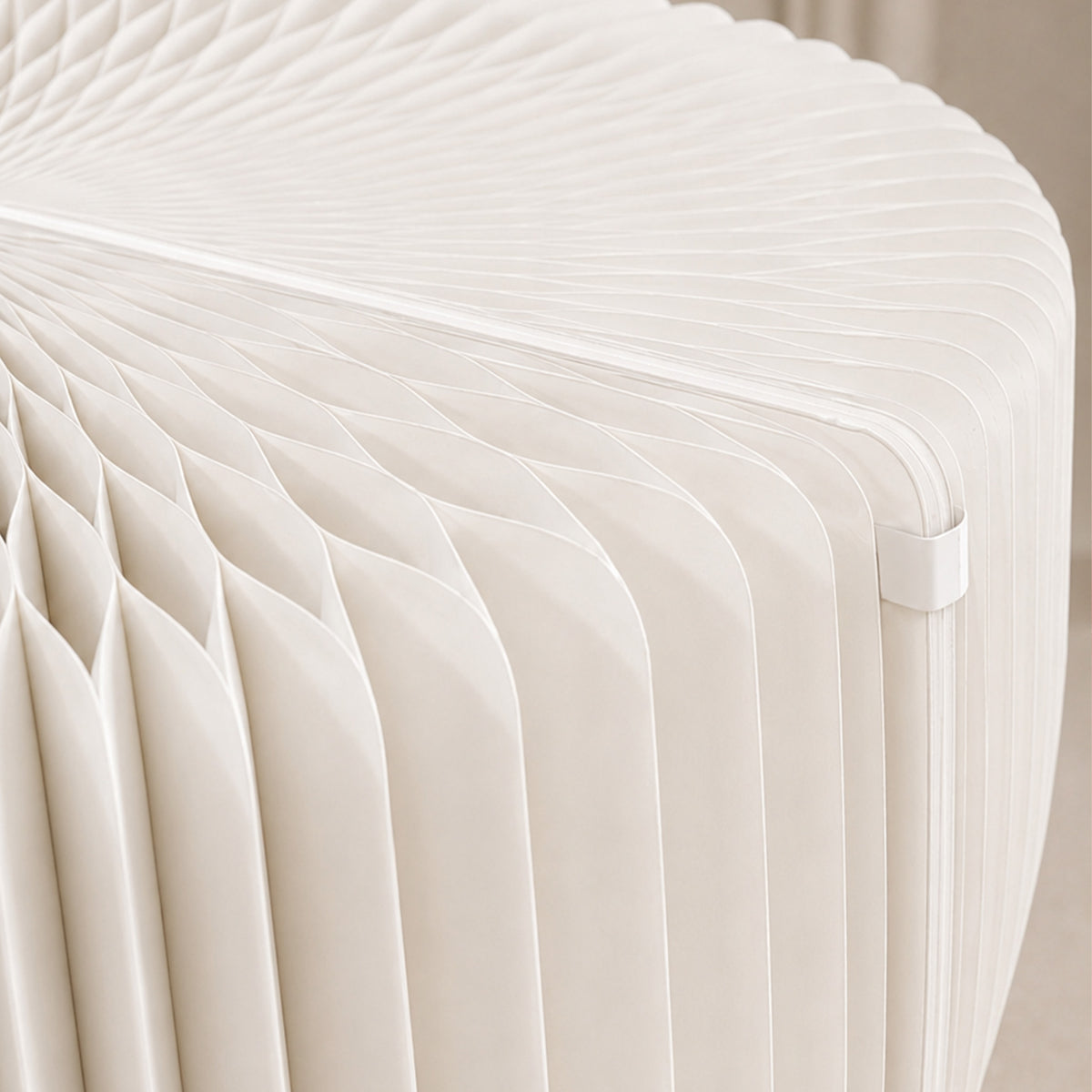 Close-up of the white LOTUS Stool B showing the expandable honeycomb paper structure without the seat cushion