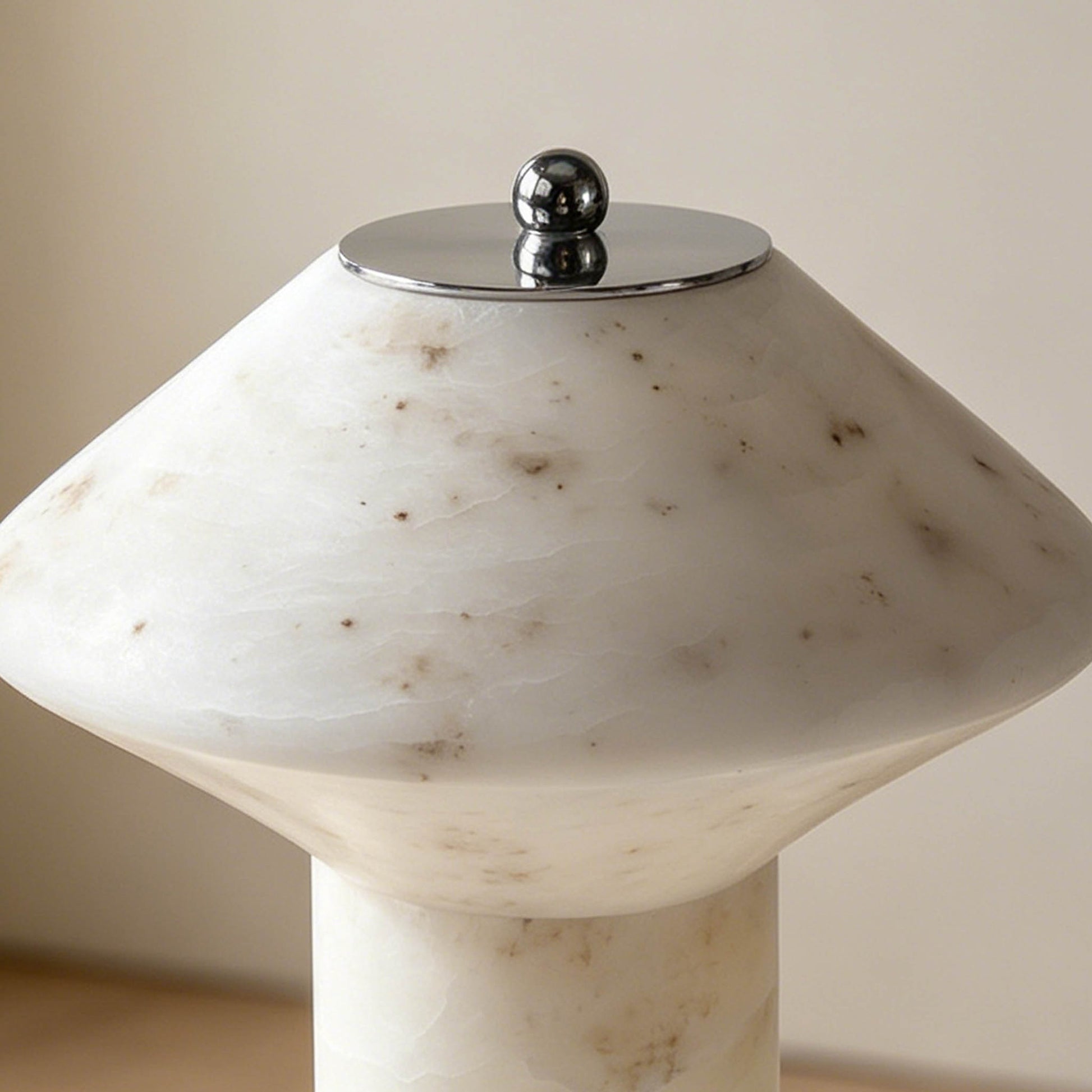 Close-up of the marble lamp shade showing natural veining, soft stone texture, and polished metal top detail.