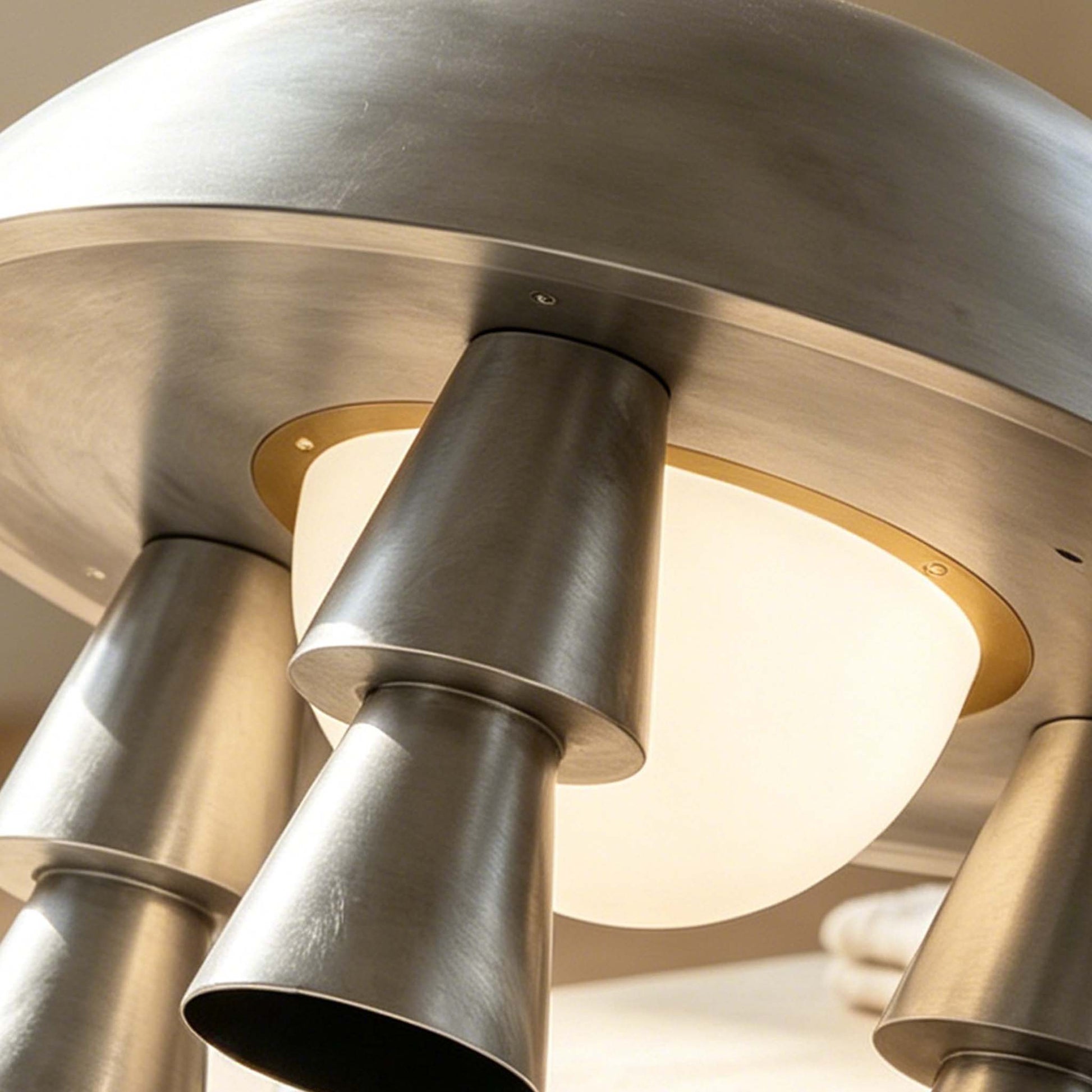 Close-up of the Metal Creative Table Lamp with brushed silver metal legs and a warm frosted glass diffuser.