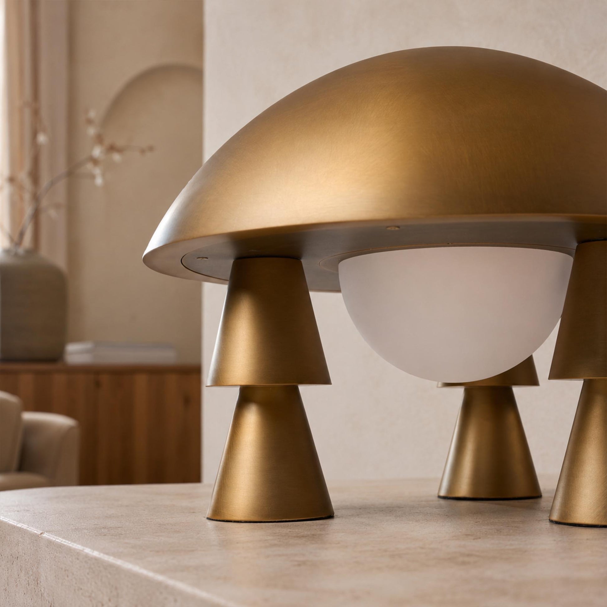 Close-up of the Metal Creative Table Lamp showing the gold dome shade, frosted glass diffuser, and conical legs.