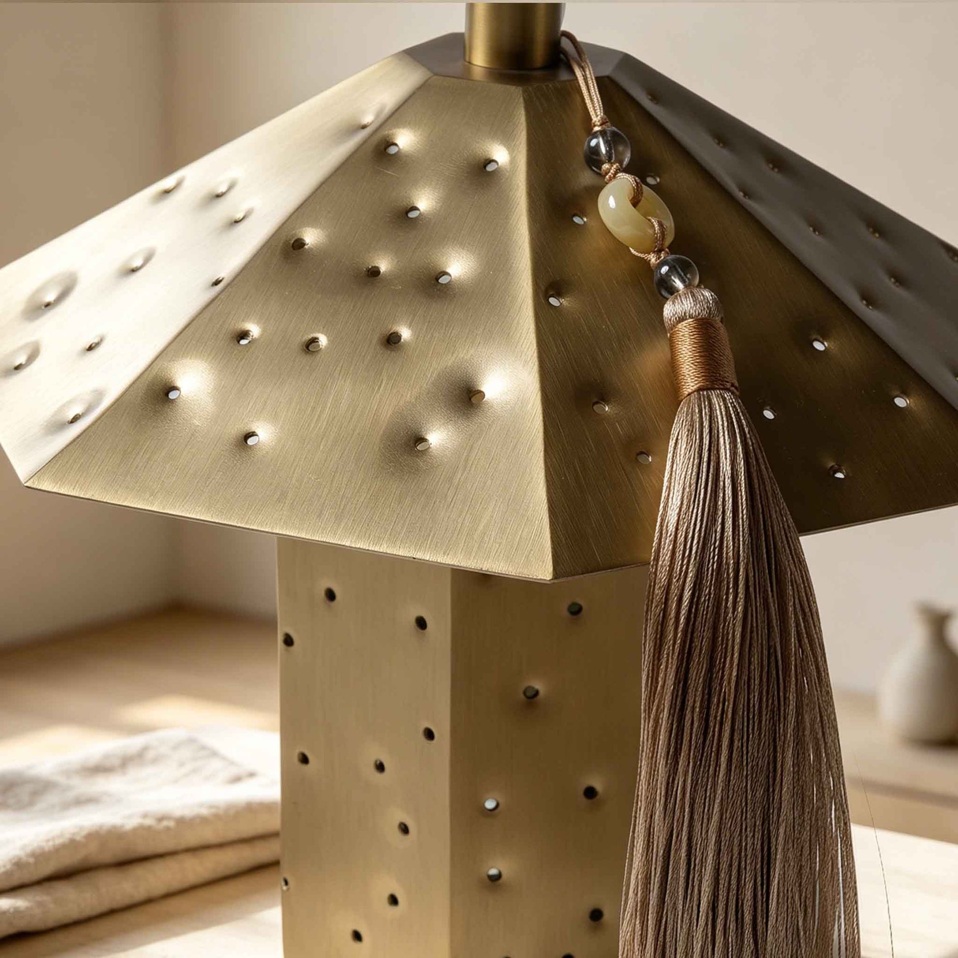 Polyhedron starry night light detail with brushed metal shade, perforated holes, and decorative tassel.