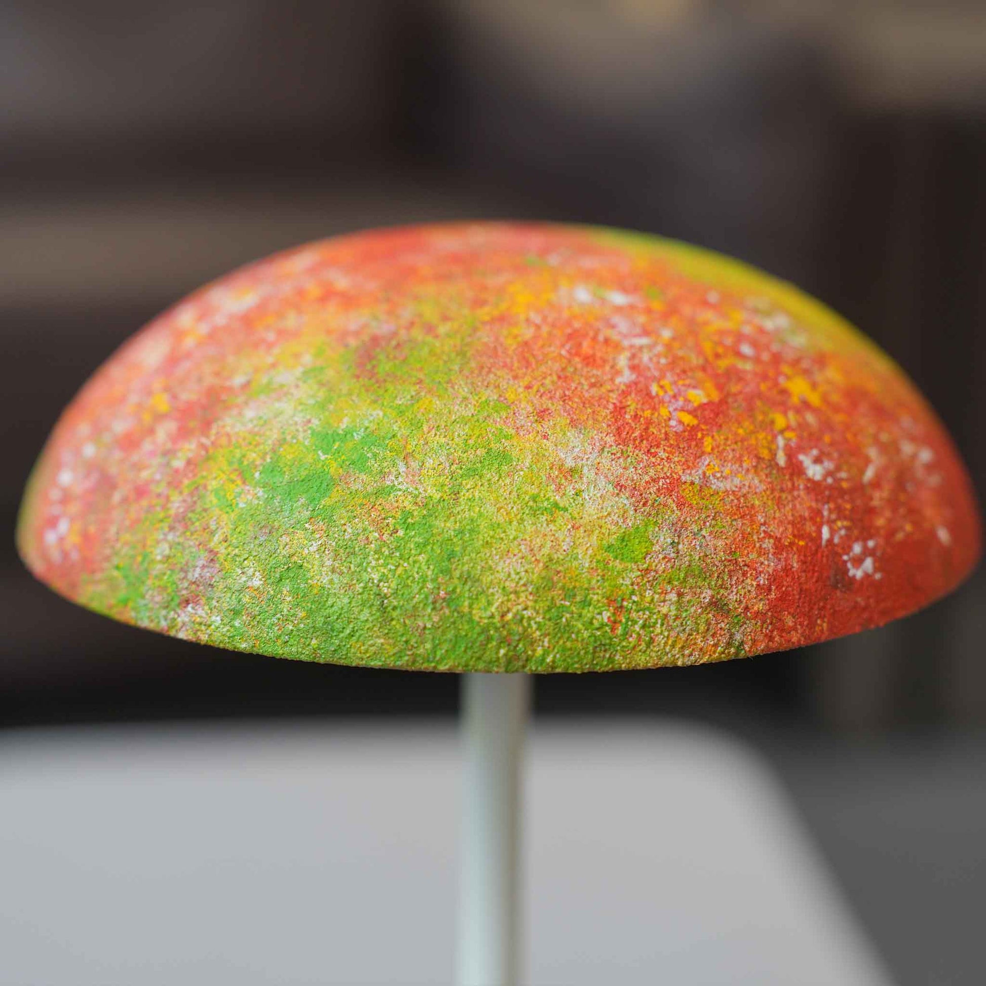 Close-up of a colorful hand-painted Relax-W lamp shade showing textured red, green, and yellow artwork.