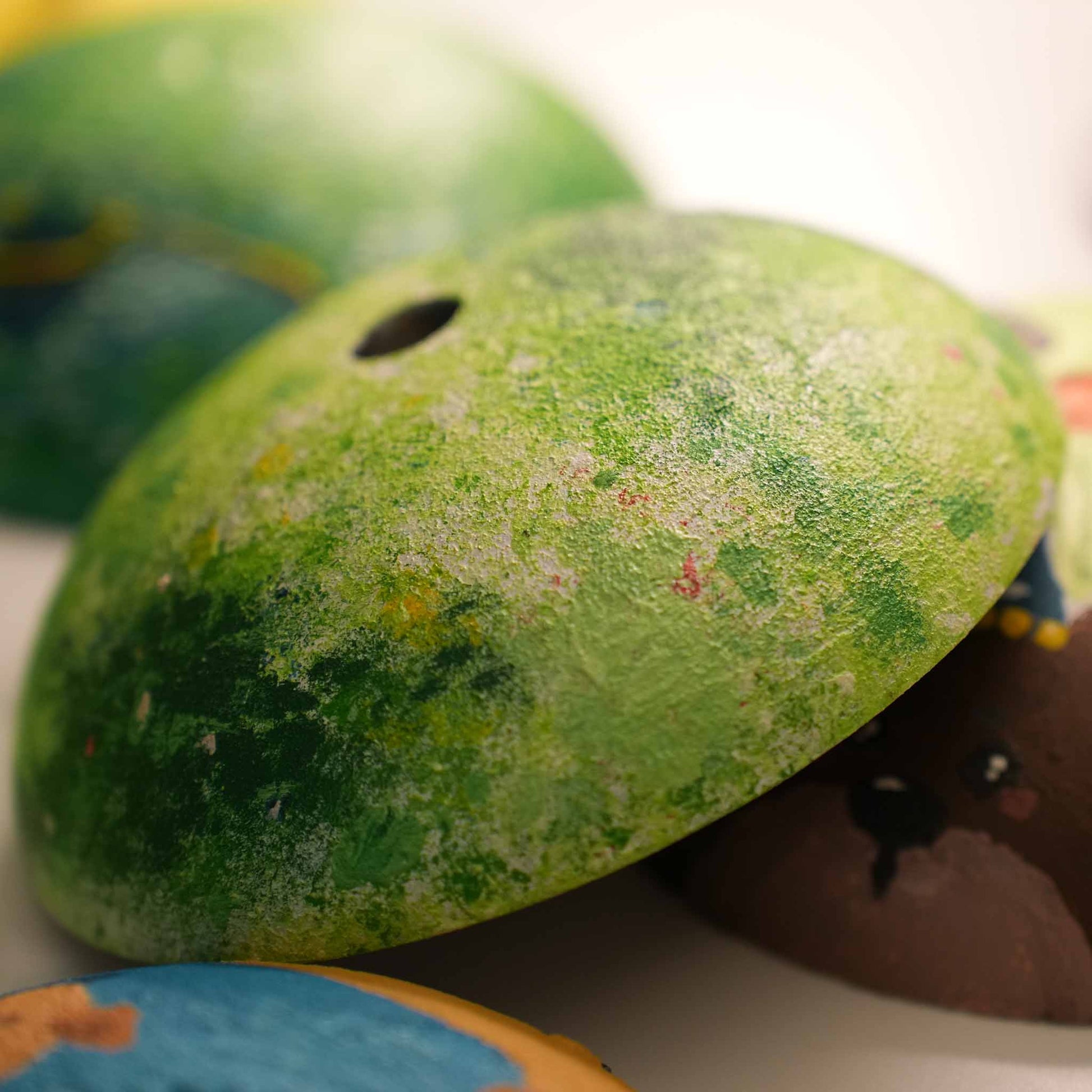 Close-up of a green hand-painted Relax-W lamp shade showing textured micro-cement and layered color detail.