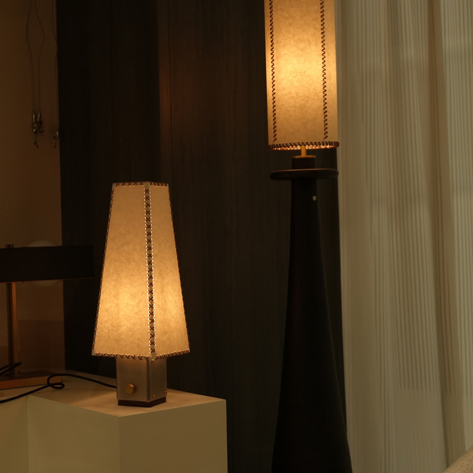 The handmade parchment table lamp casting a warm ambient glow in a cozy room.